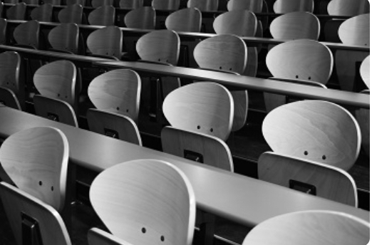 Photograph of rows of
              school desks.